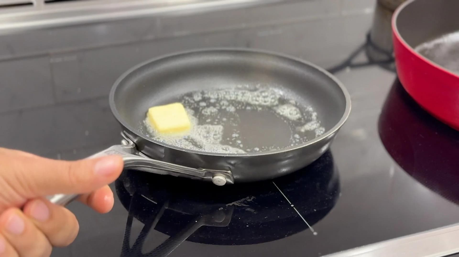 Butter melting in a skillet on a stovetop, first step for caramelizing onions for sliders.