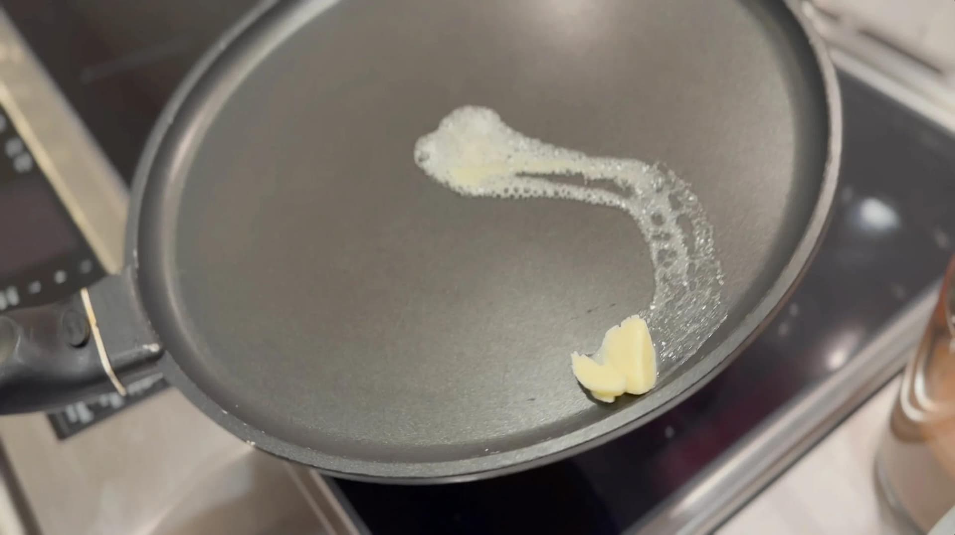 Melted butter and sugar in a non-stick pan being prepared for cooking chocolate crepes.