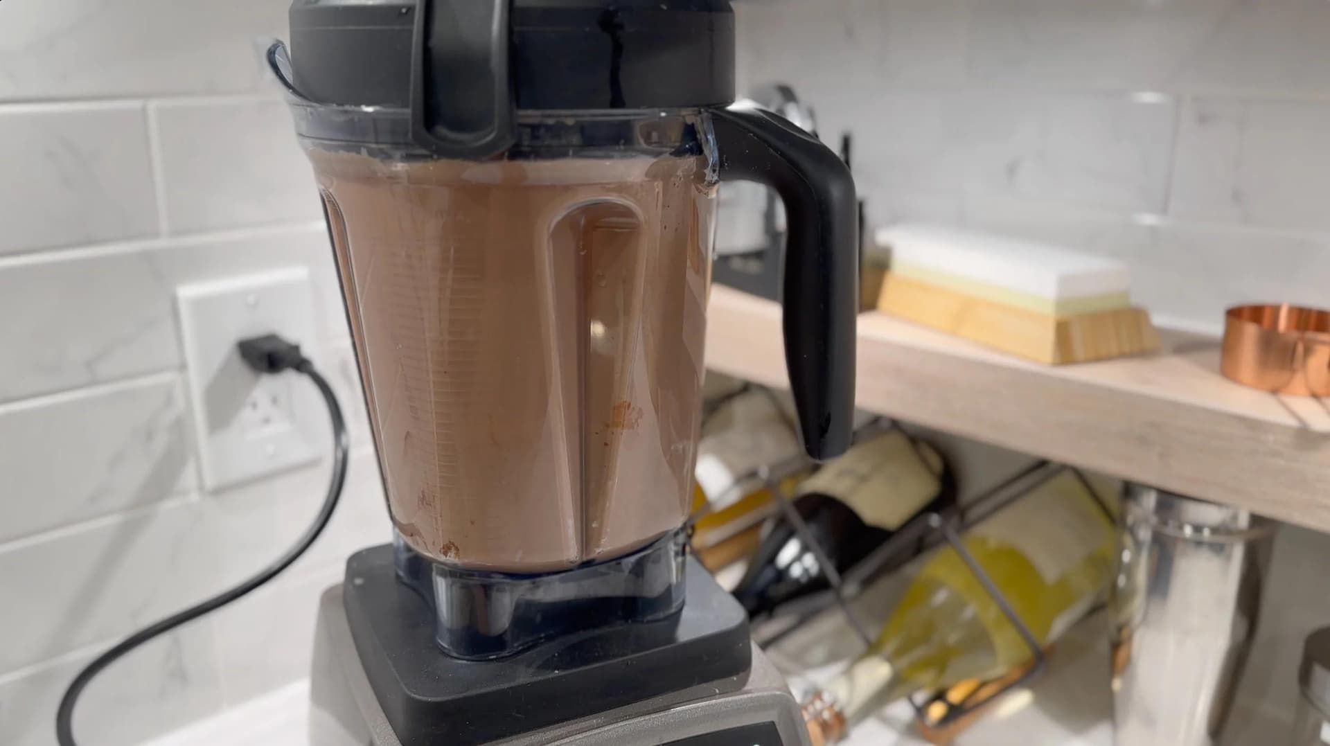 Blender filled with chocolate-colored crepe batter on kitchen counter