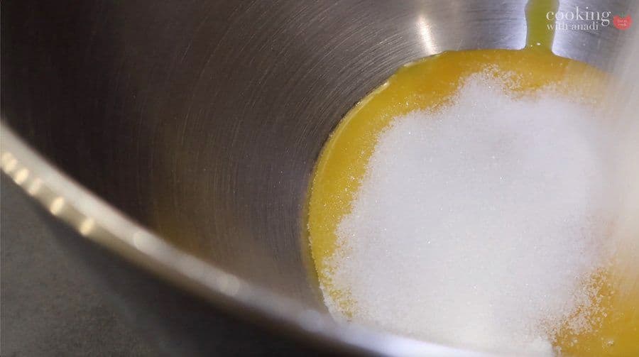 Egg yolks and sugar whisked together in a metal bowl until pale and thick at ribbon stage.