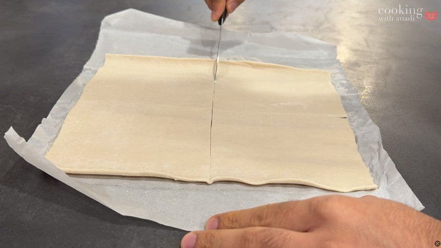 Folding puff pastry square diagonally to seal potato filling inside for air fryer aloo patty.