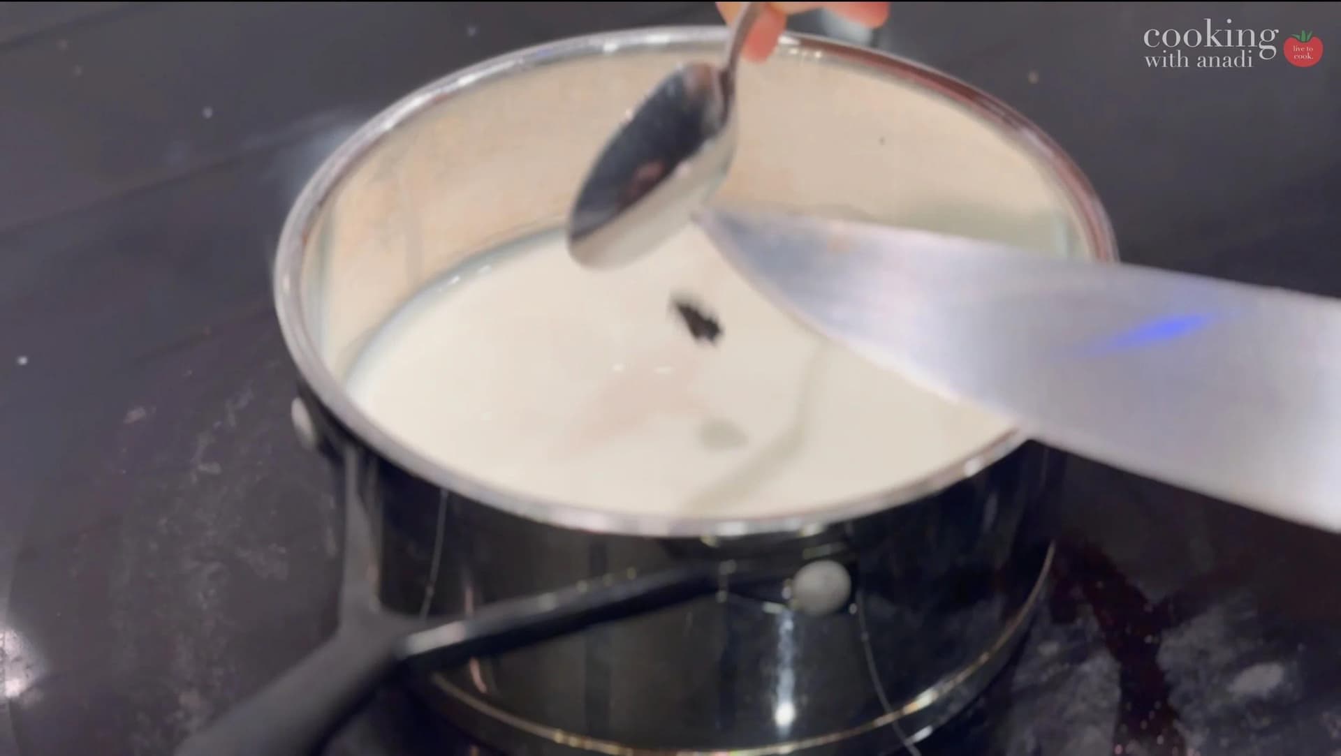 Straining spiced milk through a fine mesh sieve into a saucepan for banana cream pie custard.