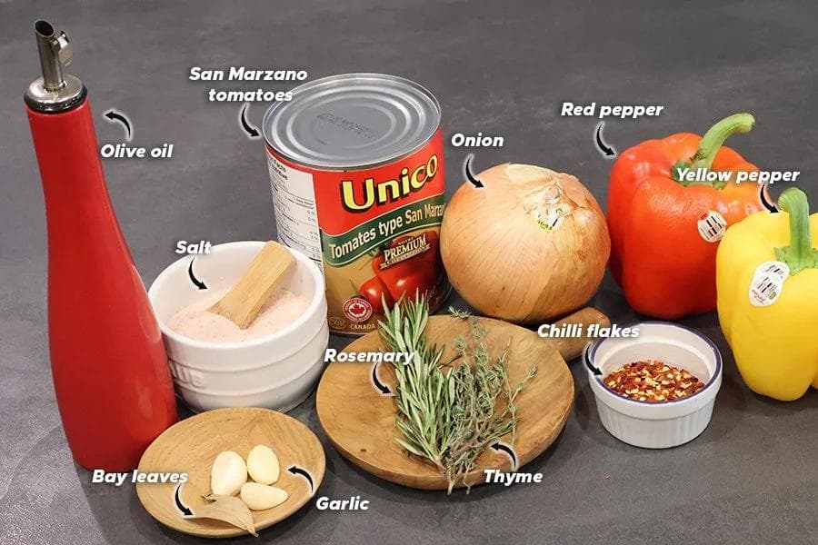 Ingredients for Basque Piperade: olive oil, canned San Marzano tomatoes, onion, red and yellow peppers, rosemary, thyme, garlic, salt, and chilli flakes.