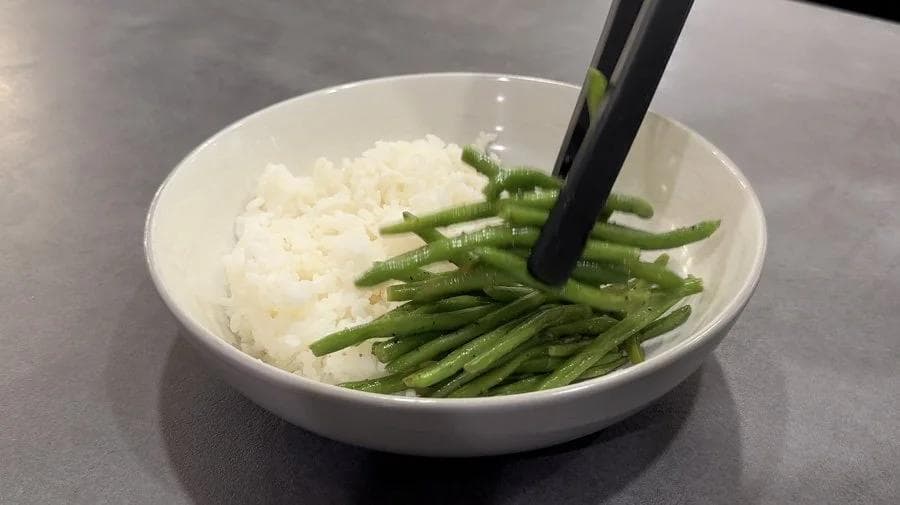 Korean tofu rice bowl with white rice, green beans, and chopsticks in a white bowl.