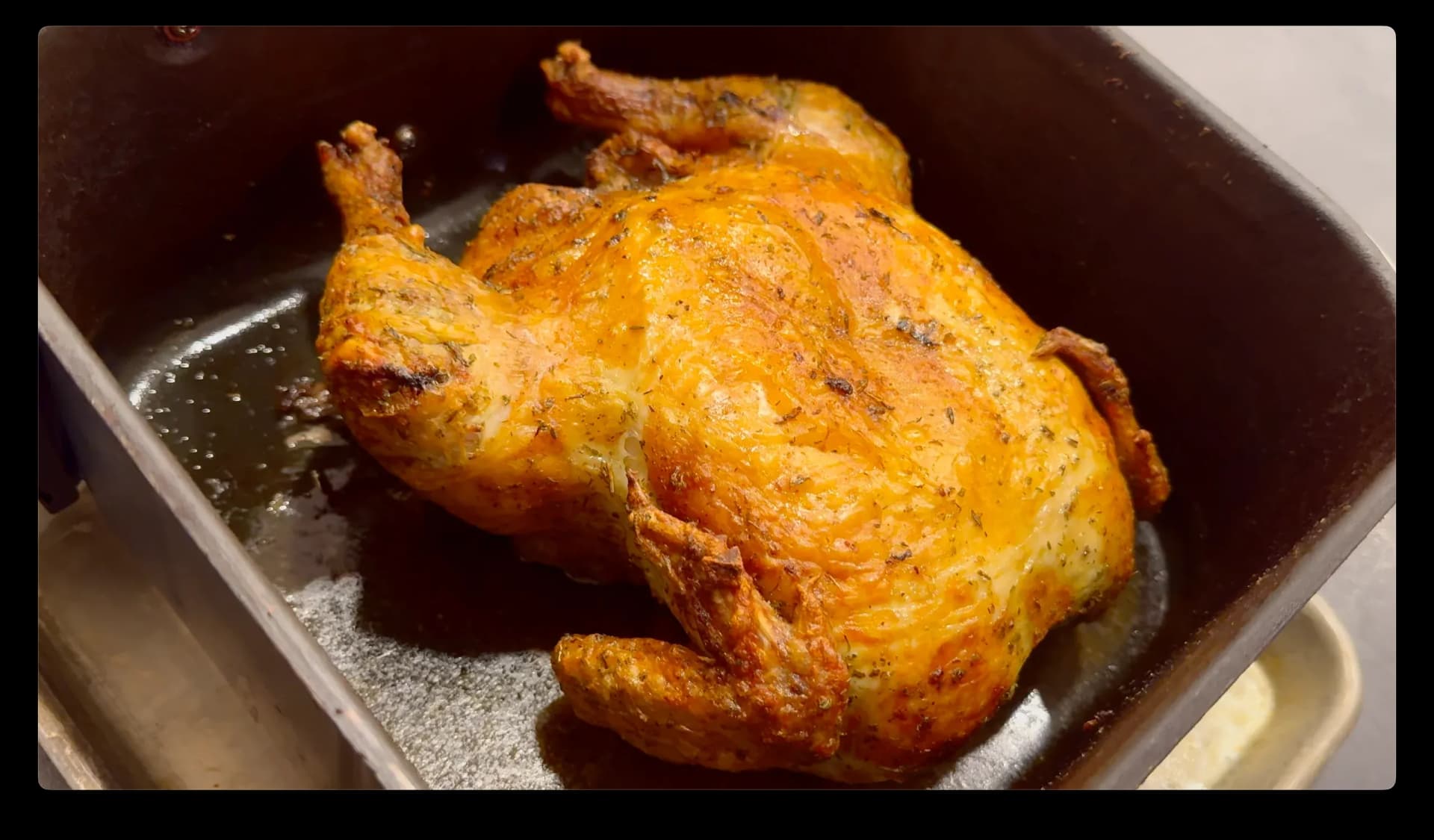 Golden-brown whole chicken in air fryer basket, cooked until skin is crispy and golden.