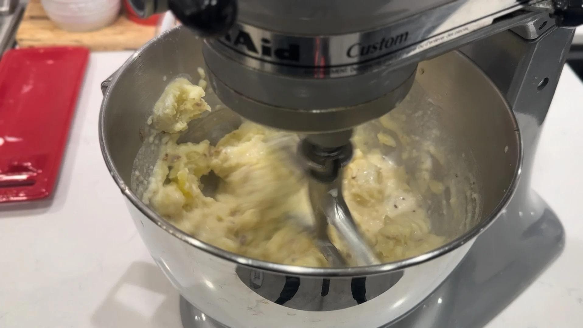 Stand mixer with paddle attachment mixing creamy mashed potatoes in stainless steel bowl