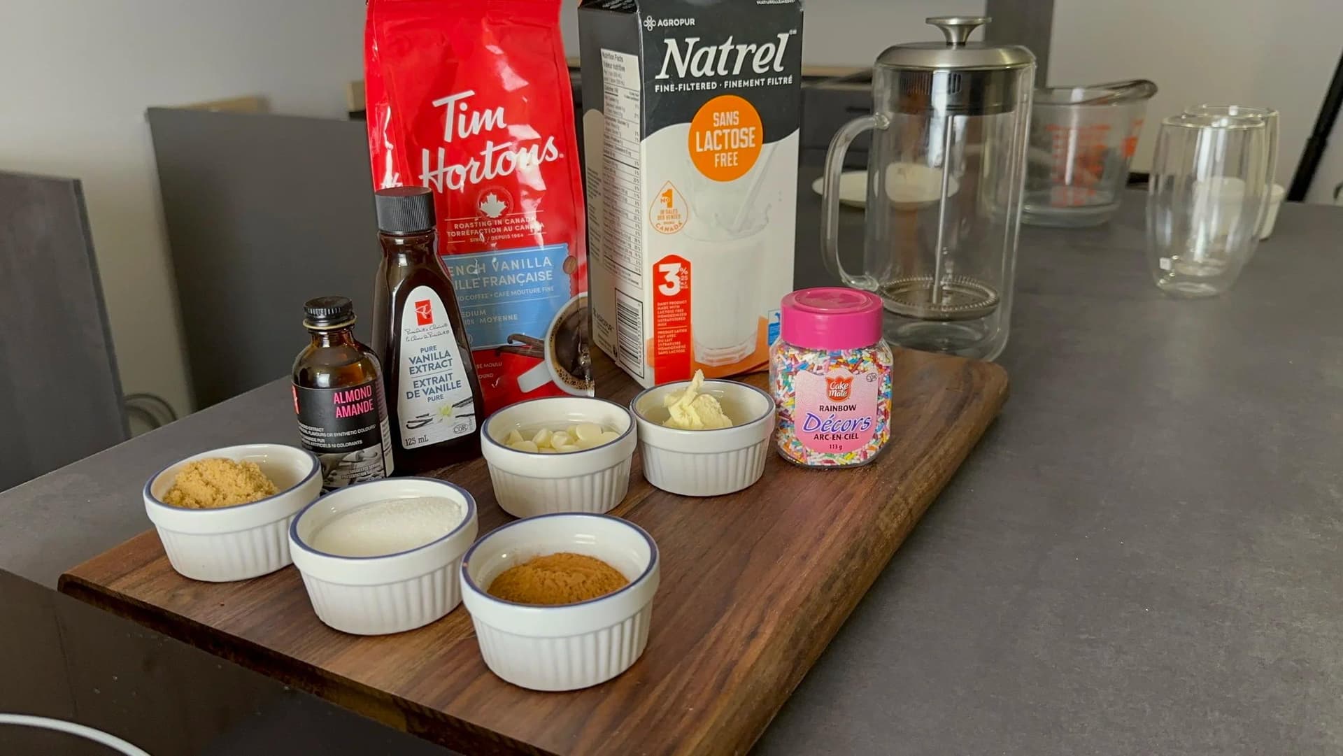 Ingredients for homemade Starbucks sugar cookie latte arranged in white ramekins on wooden board with Tim Hortons coffee and Natrel milk.