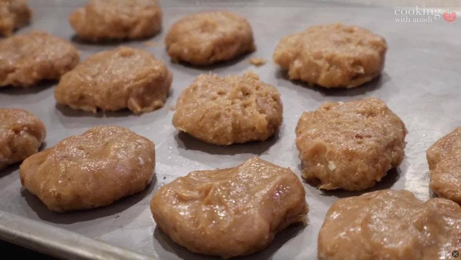 Golden-brown air fried chicken nuggets arranged on parchment paper, crispy and cooked through.