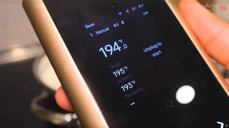 Digital thermometer showing milk temperature at 194°F during paneer making process