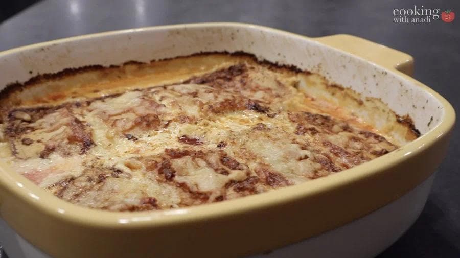 Baked gluten-free Croatian strukli in a ceramic dish with golden-brown top and melted cheese, fresh from the oven.