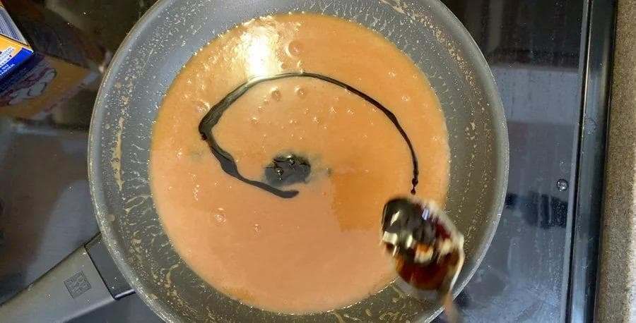 Whiskey caramel sauce cooling in a pan with an immersion blender and whisk visible.