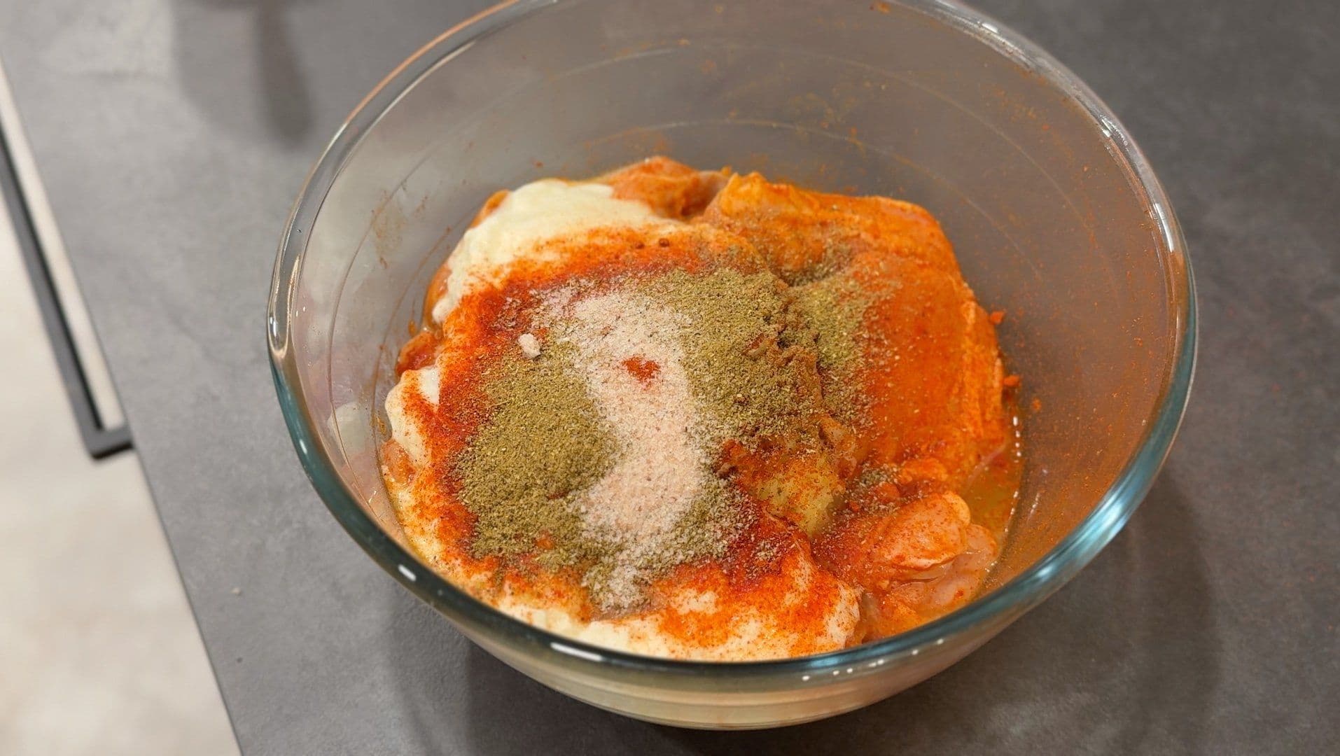 Second tandoori marinade in bowl with spices sprinkled on top, ready to mix.