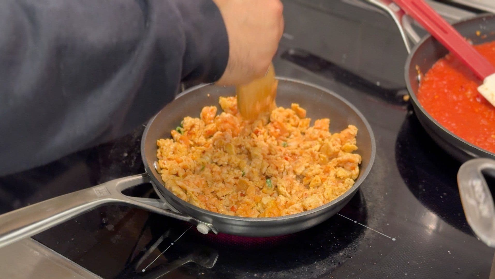 Cooked ground Italian sausage being stirred in a skillet on a stovetop.