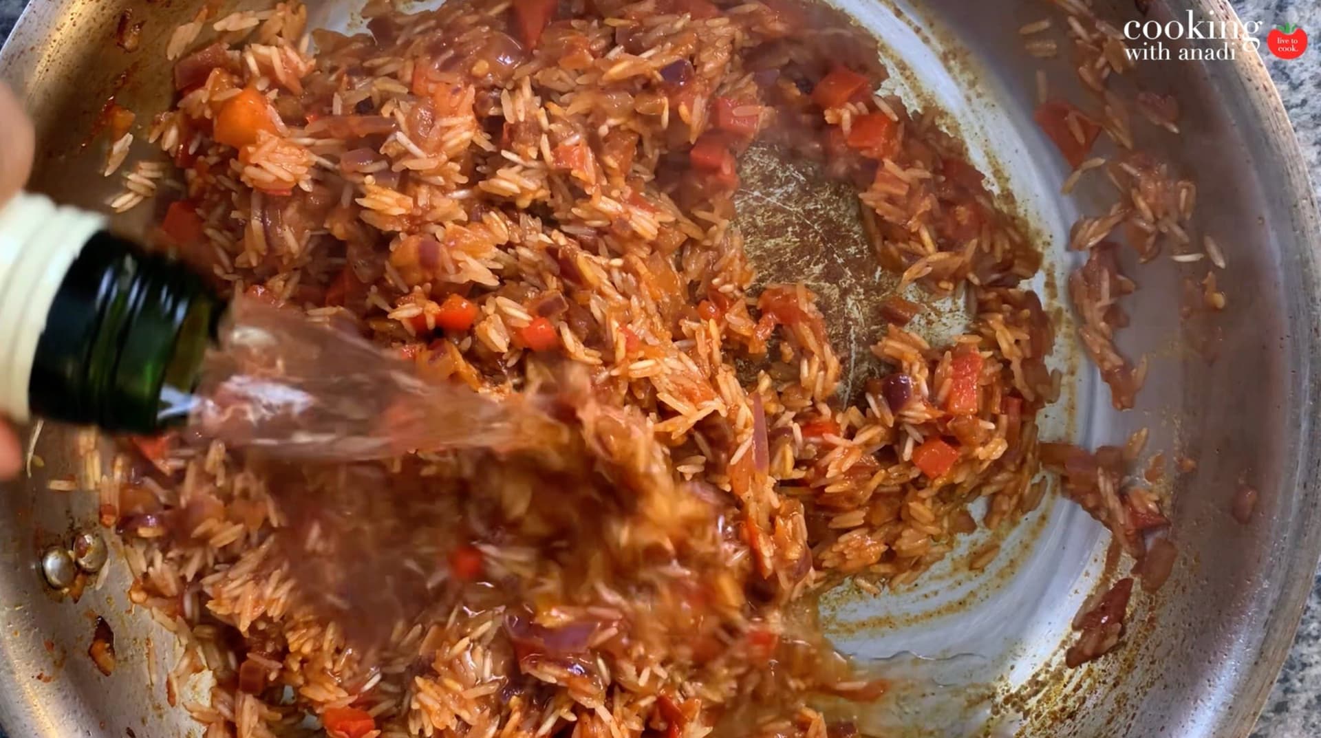 Shredded chicken mixed with tomatoes and spices in a pot during preparation for one-pot chicken and rice.