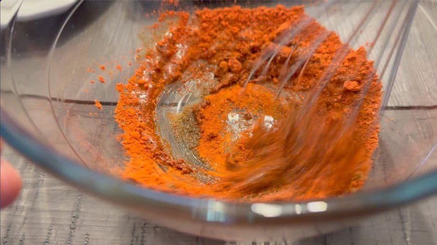 Spice mixture for chimichurri sauce being mixed in a glass bowl with a spoon