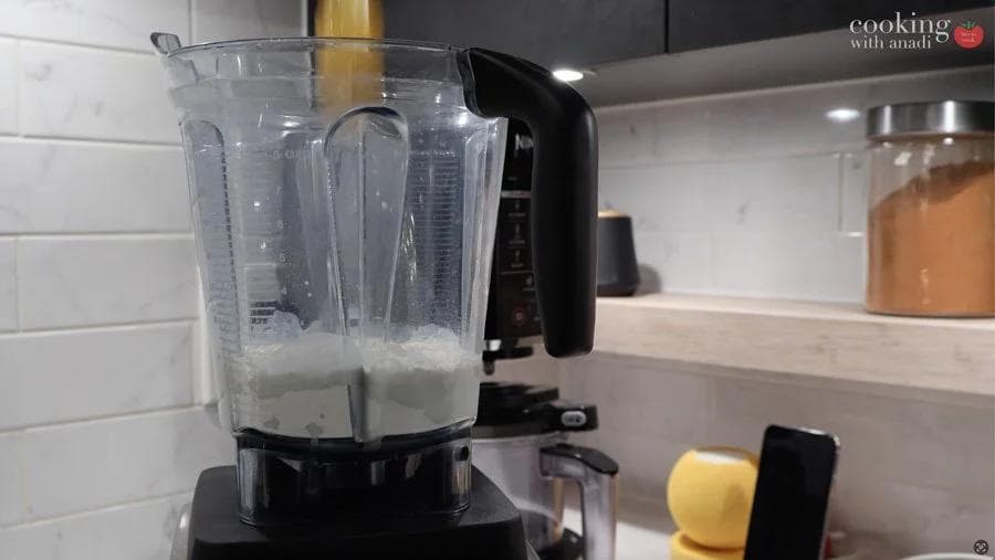 Blender filled with crepe batter being prepared for pumpkin crepes recipe.