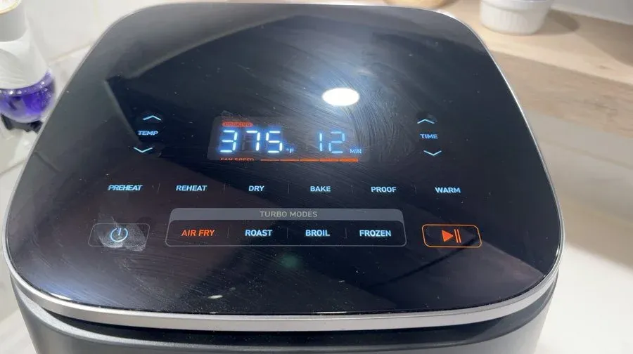 Air fryer display showing 379°F temperature set to air fry mode during cooking of fritters.