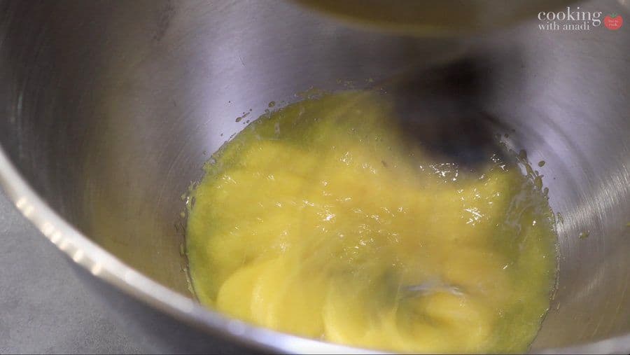 Egg yolks and sugar whisked to pale, thick ribbon stage in a stainless steel mixing bowl.
