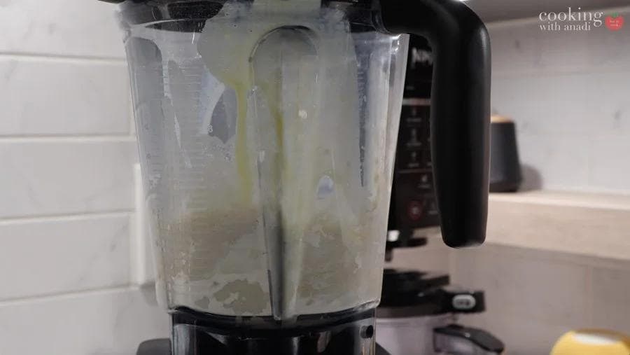 Crepe batter blended smooth in a food processor, ready to be transferred to a bowl for chilling.