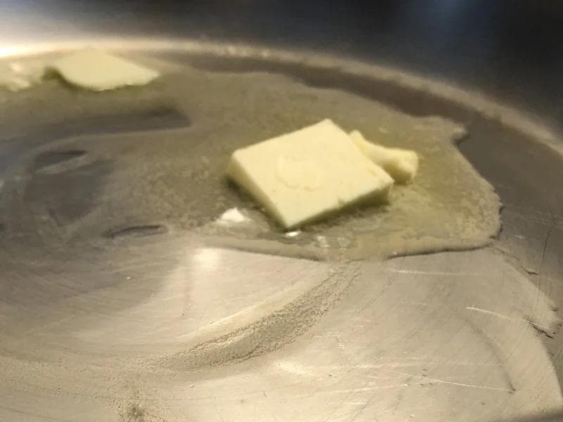 Butter melting in a pan with flour being added to make a roux for bechamel sauce.