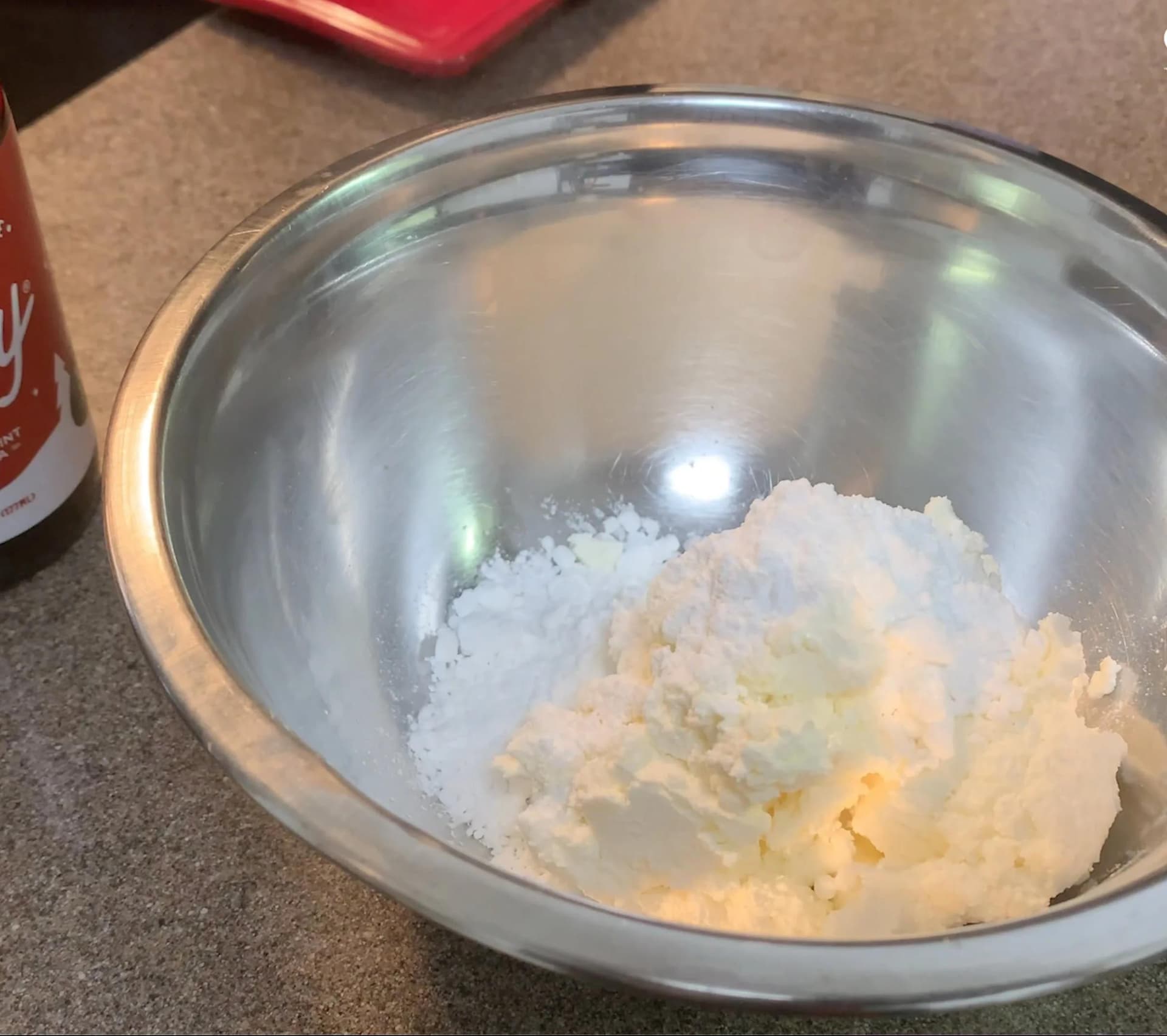 Cream cheese and powdered sugar mixed together in a metal bowl for peppermint mocha glaze.
