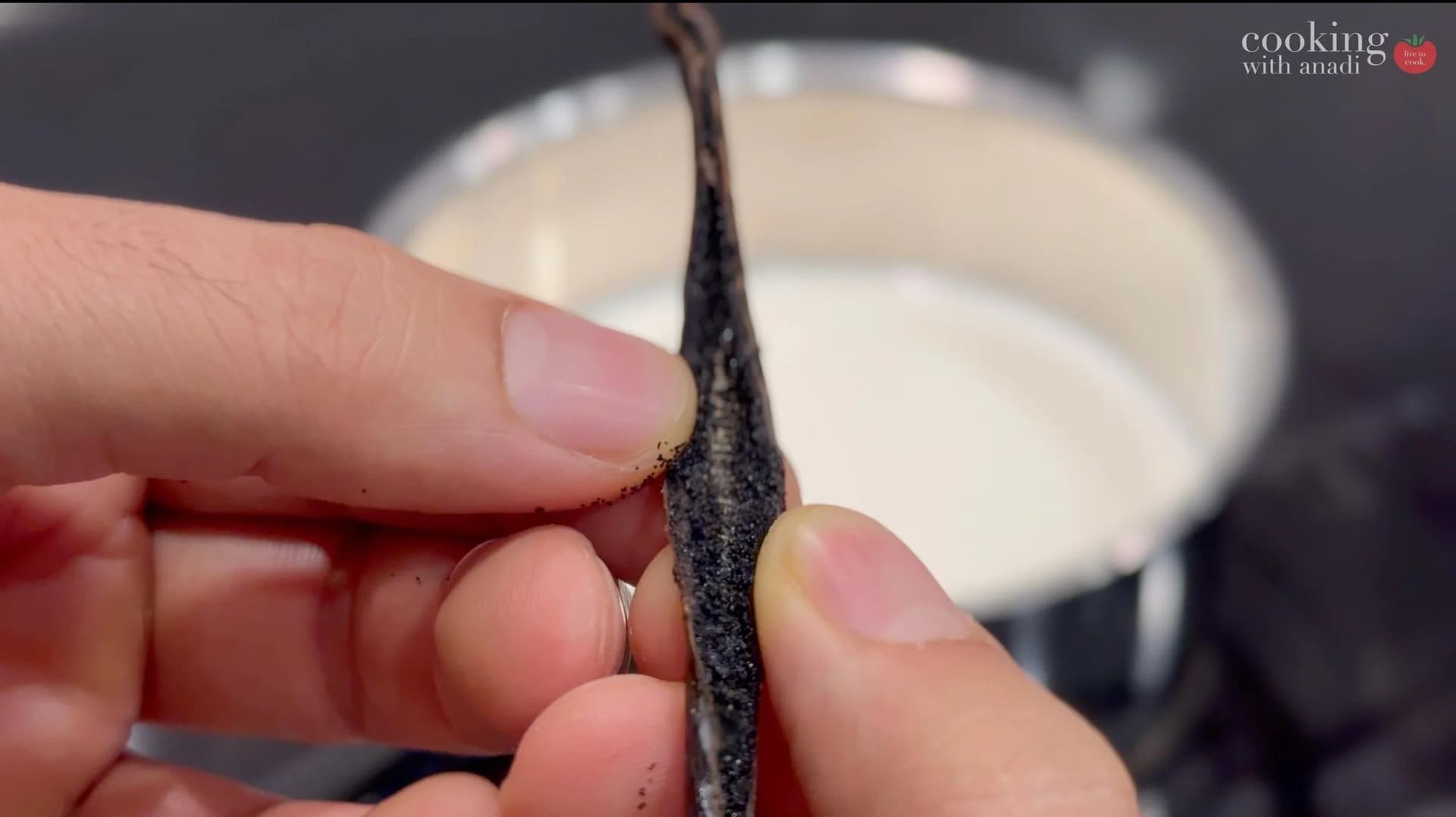 Splitting a vanilla bean pod to reveal seeds for infusing into milk for custard.