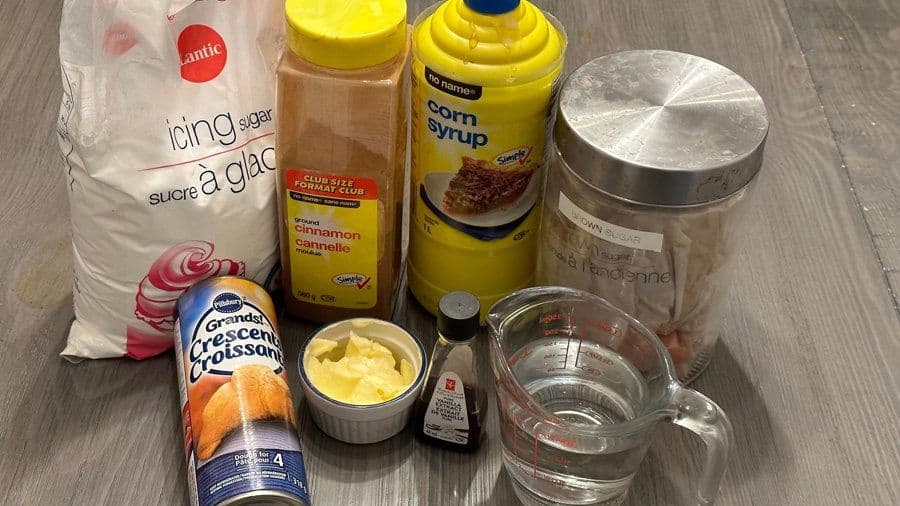 Ingredients for air fryer cinnamon rolls: crescent rolls, icing sugar, cinnamon, corn syrup, butter, and water.