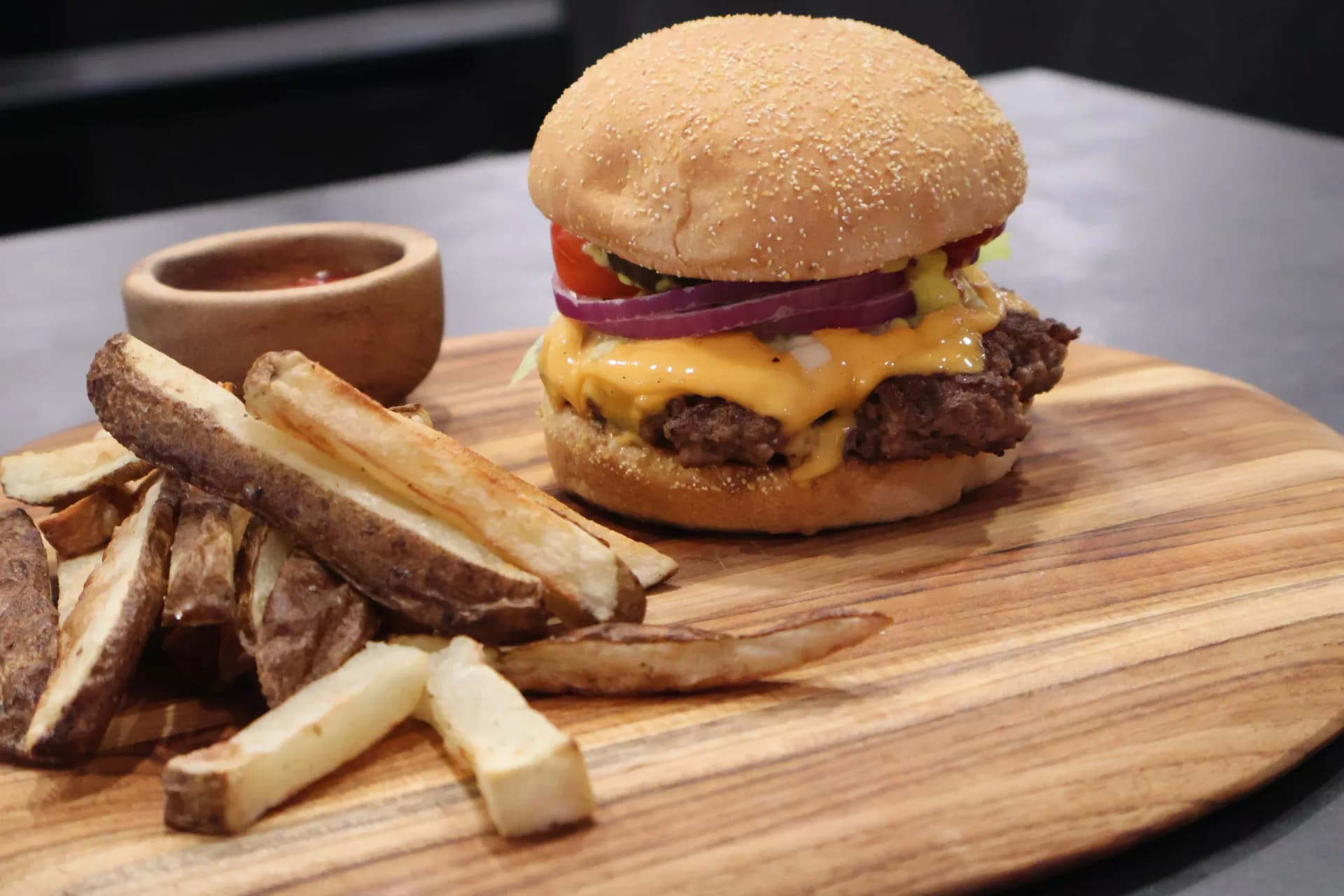 Juicy cheeseburger with melted cheddar and red onion on sesame bun, served with crispy fries and gravy.