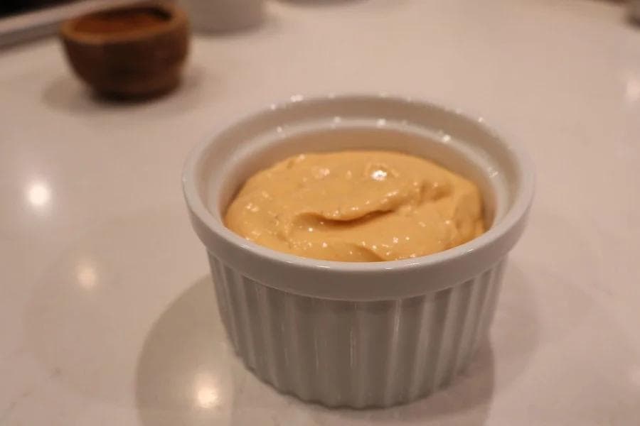 Pumpkin cream cheese filling whisked smooth in a white ramekin, ready to chill before assembly.