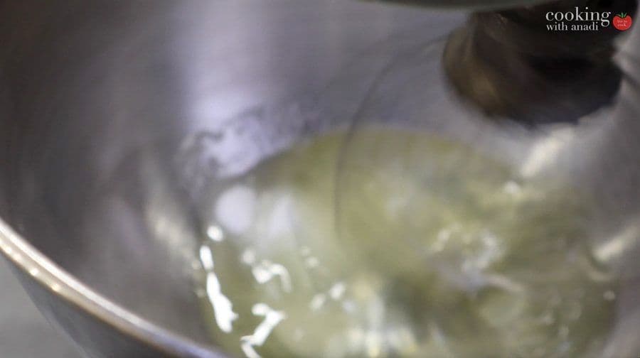Whipped egg whites with soft peaks in a mixer bowl, ready to be folded into chocolate mousse.