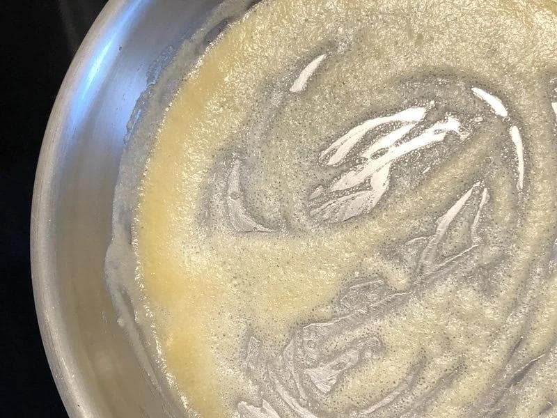 Nutty-smelling roux of melted butter and flour in a pan, ready for milk to be added.