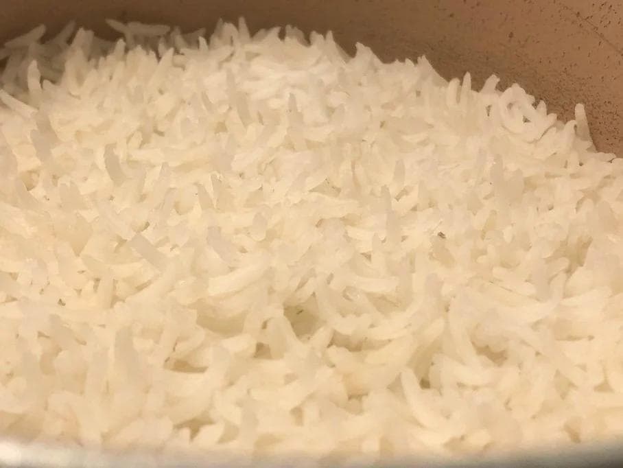 Cooked white rice in a pot, fluffy and tender after simmering.