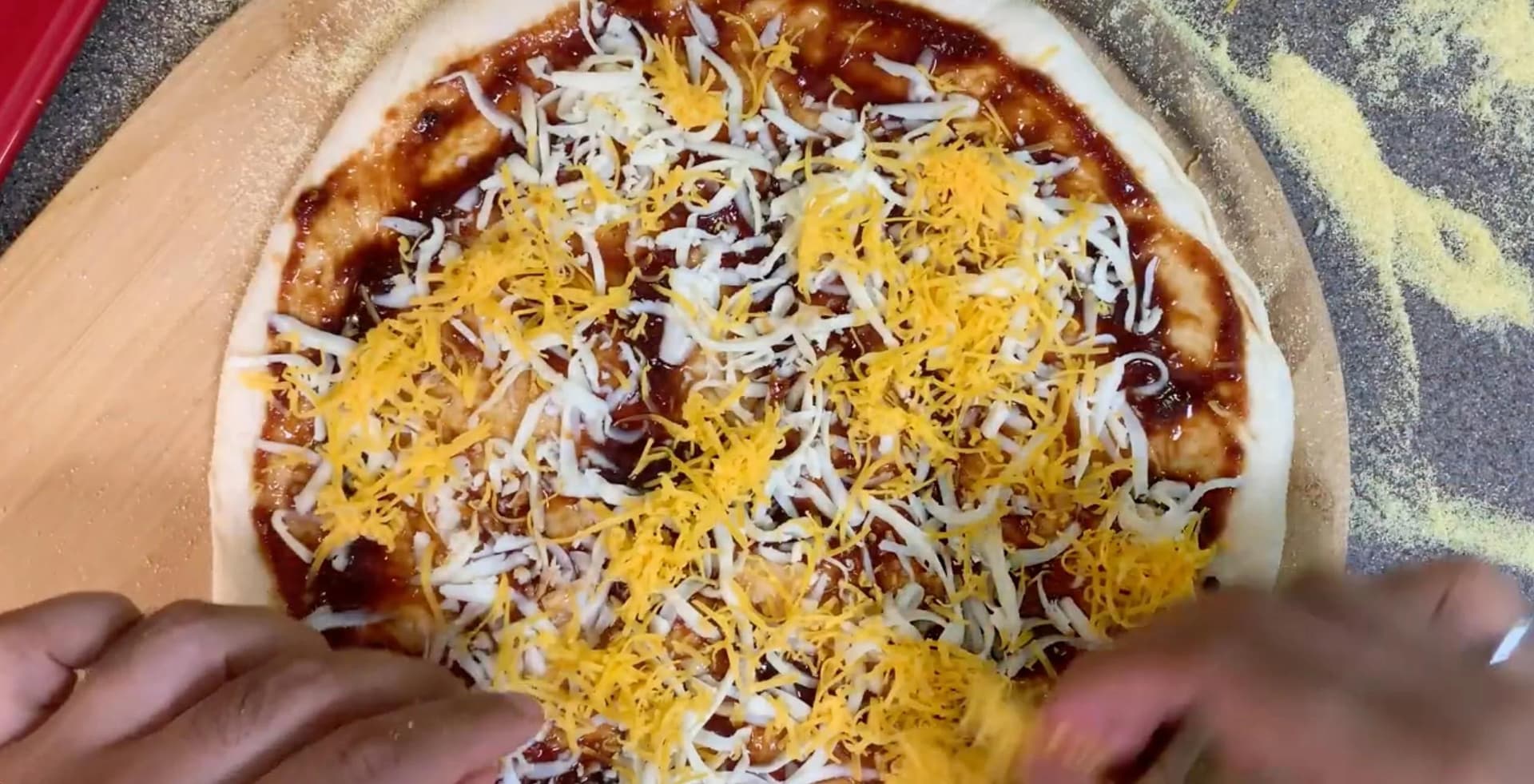 BBQ chicken naan flatbread pizza topped with melted mozzarella and cheddar cheese before baking.