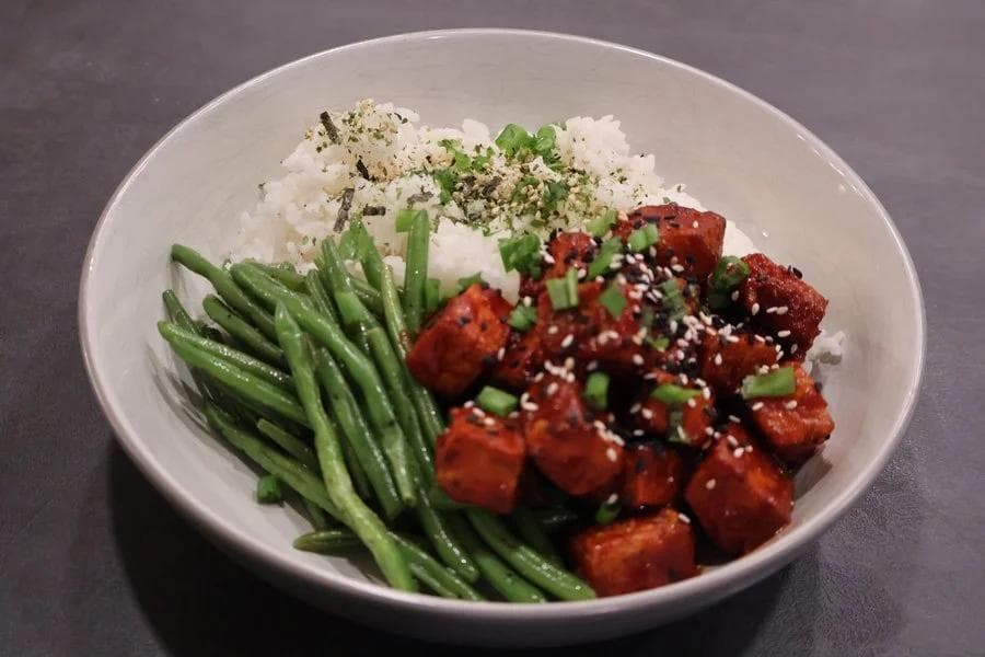 Crispy Korean air fryer tofu served in a bowl with white rice, green beans, and sesame seeds.