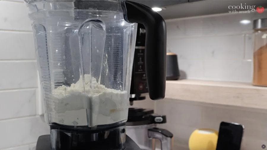 Blended pumpkin crepe batter in a food processor, smooth and ready to chill.