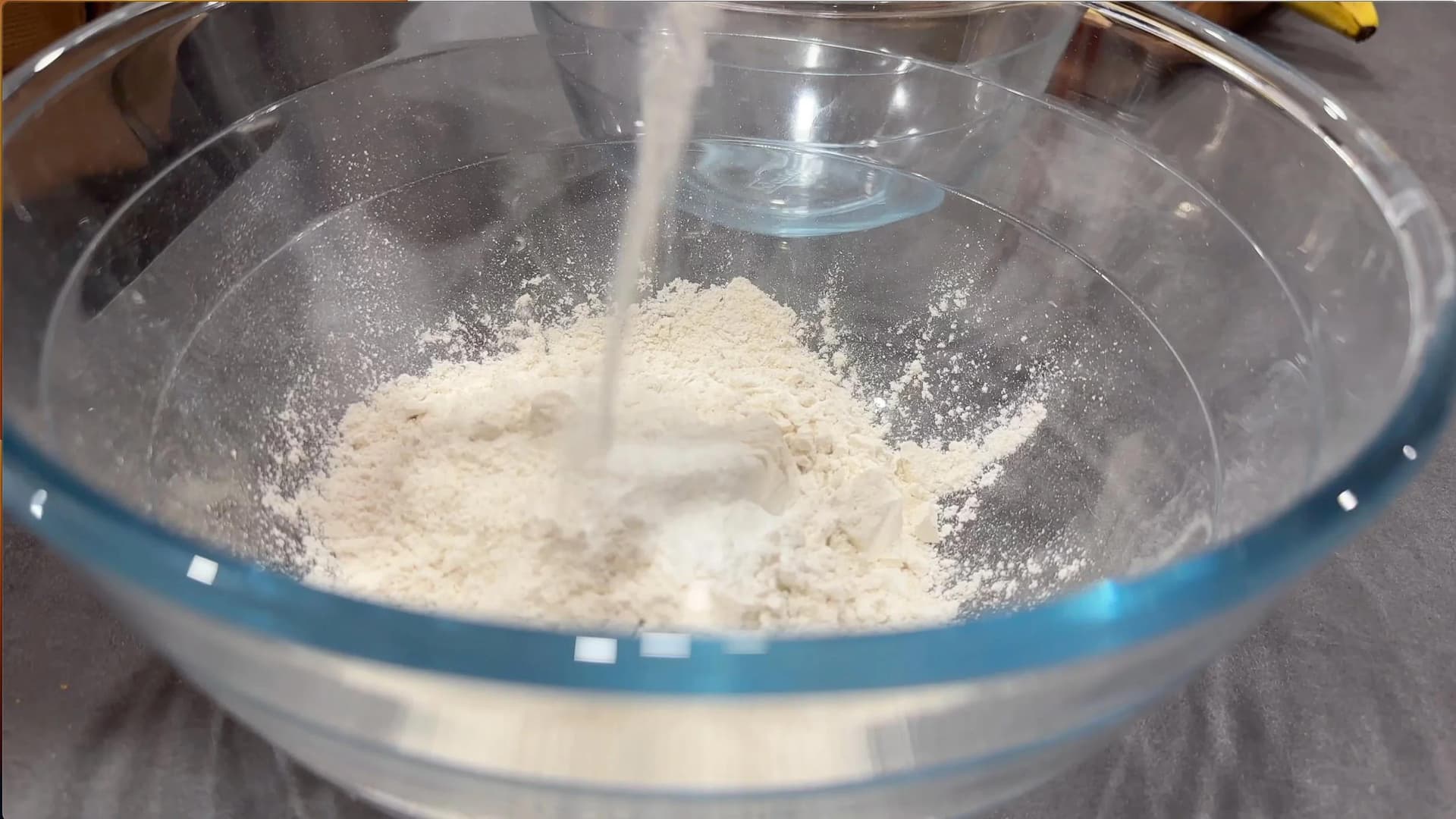 Dry ingredients being sifted into a mixing bowl for gluten-free banana brownies.