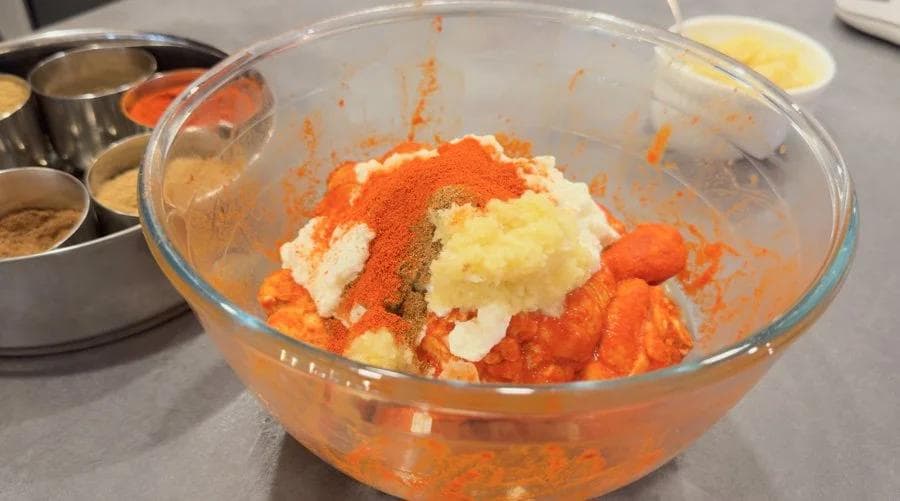 Second tandoori marinade in glass bowl with yogurt, spices, and ginger-garlic paste mixed together