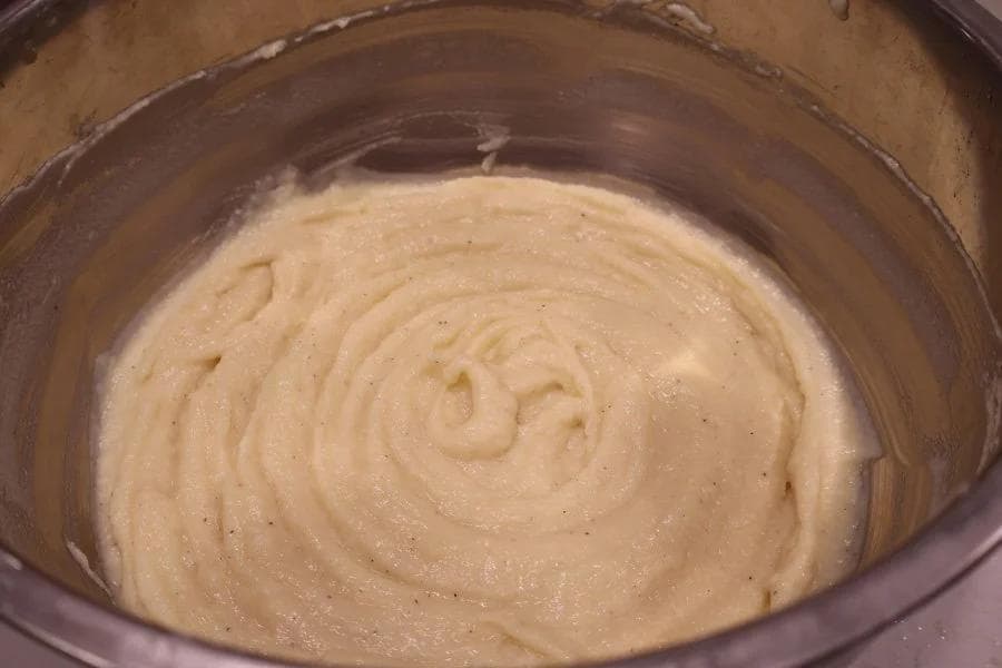 Creamy mashed potatoes in a slow cooker with a smooth, whipped texture and spiral pattern from mixing.