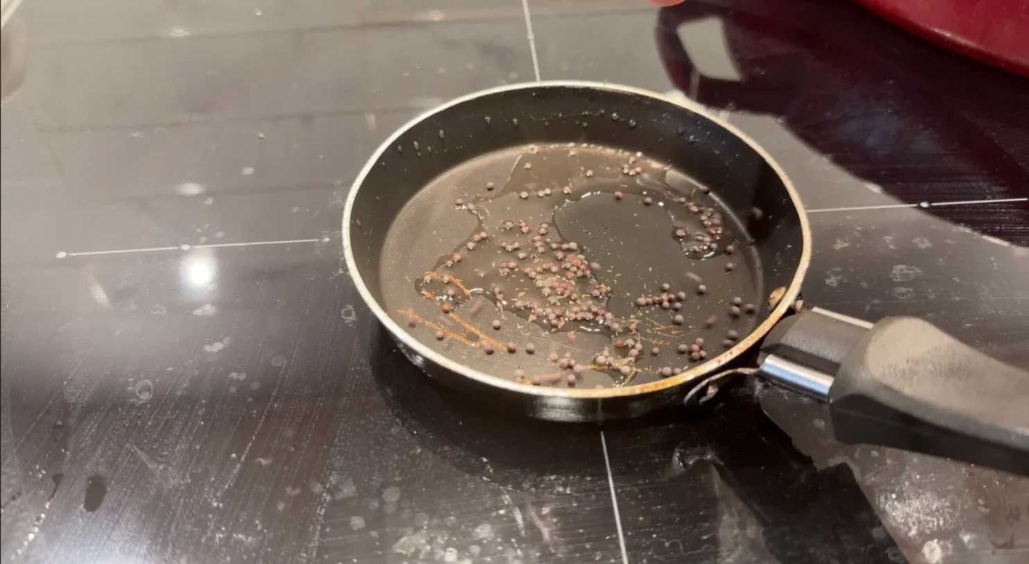 Chana dal being roasted in a pan with coconut oil, turning lightly golden brown.