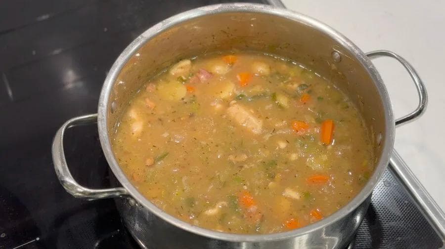 Country harvest chicken stew simmering in a pot with vegetables and broth, ready to serve.