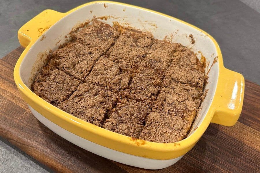 Unbaked french toast casserole with cinnamon sugar topping in a yellow and white baking dish