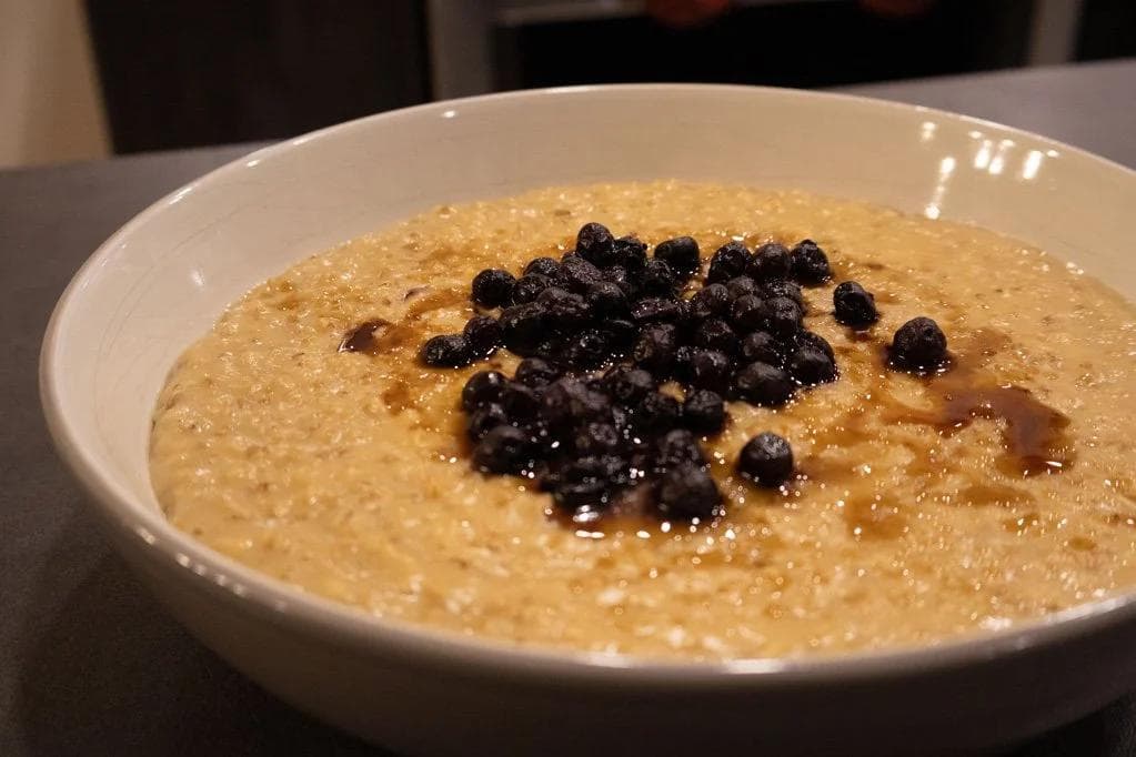 Bowl of creamy steel-cut oatmeal topped with fresh blueberries and a drizzle of honey.