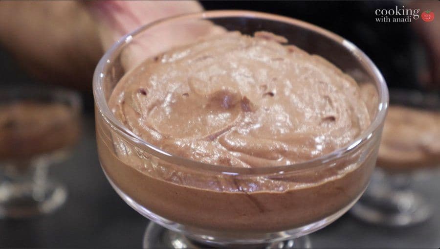 Chocolate mousse in a glass bowl with a smooth, airy texture, ready to serve.