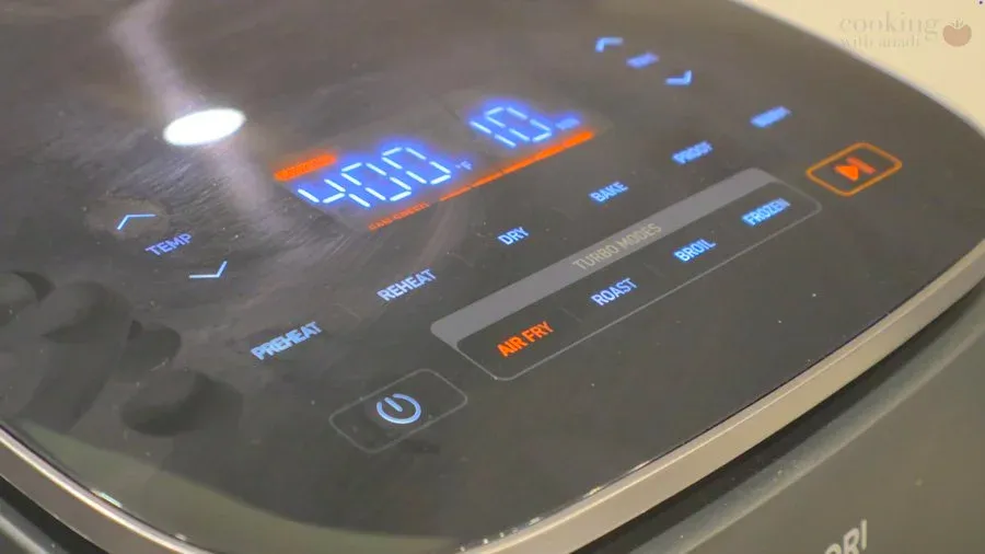 Air fryer display showing 400°F temperature setting with blue digital numbers and orange controls visible on black touchscreen panel.