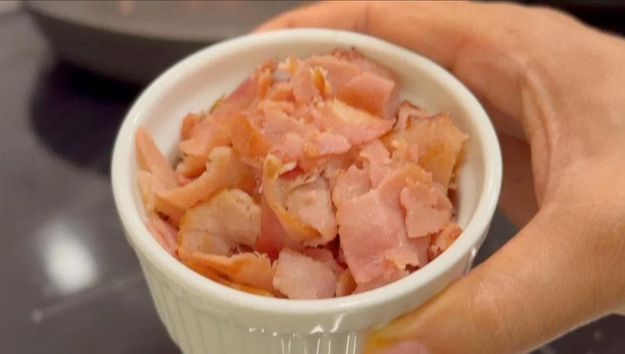 Cooked diced ham in a small white container, lightly browned and ready for breakfast burritos.