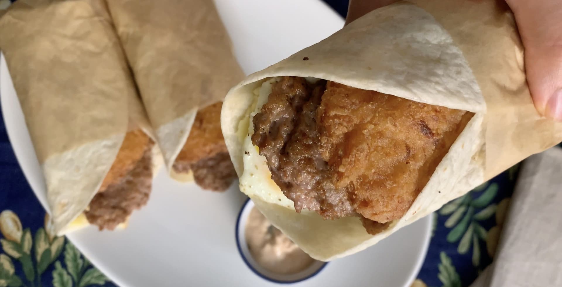 Tim Hortons Farmer's Wrap unwrapped in parchment paper, showing cooked meat filling inside a flatbread.