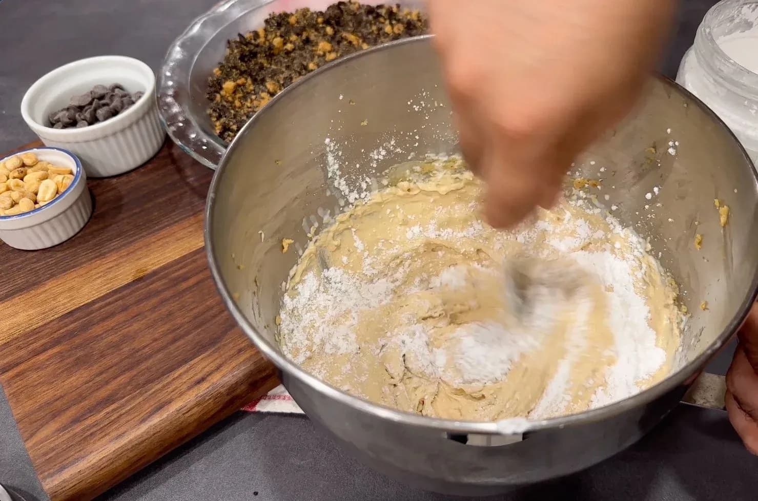 Hand mixer blending peanut butter and cream cheese filling in a metal bowl with ingredients nearby.