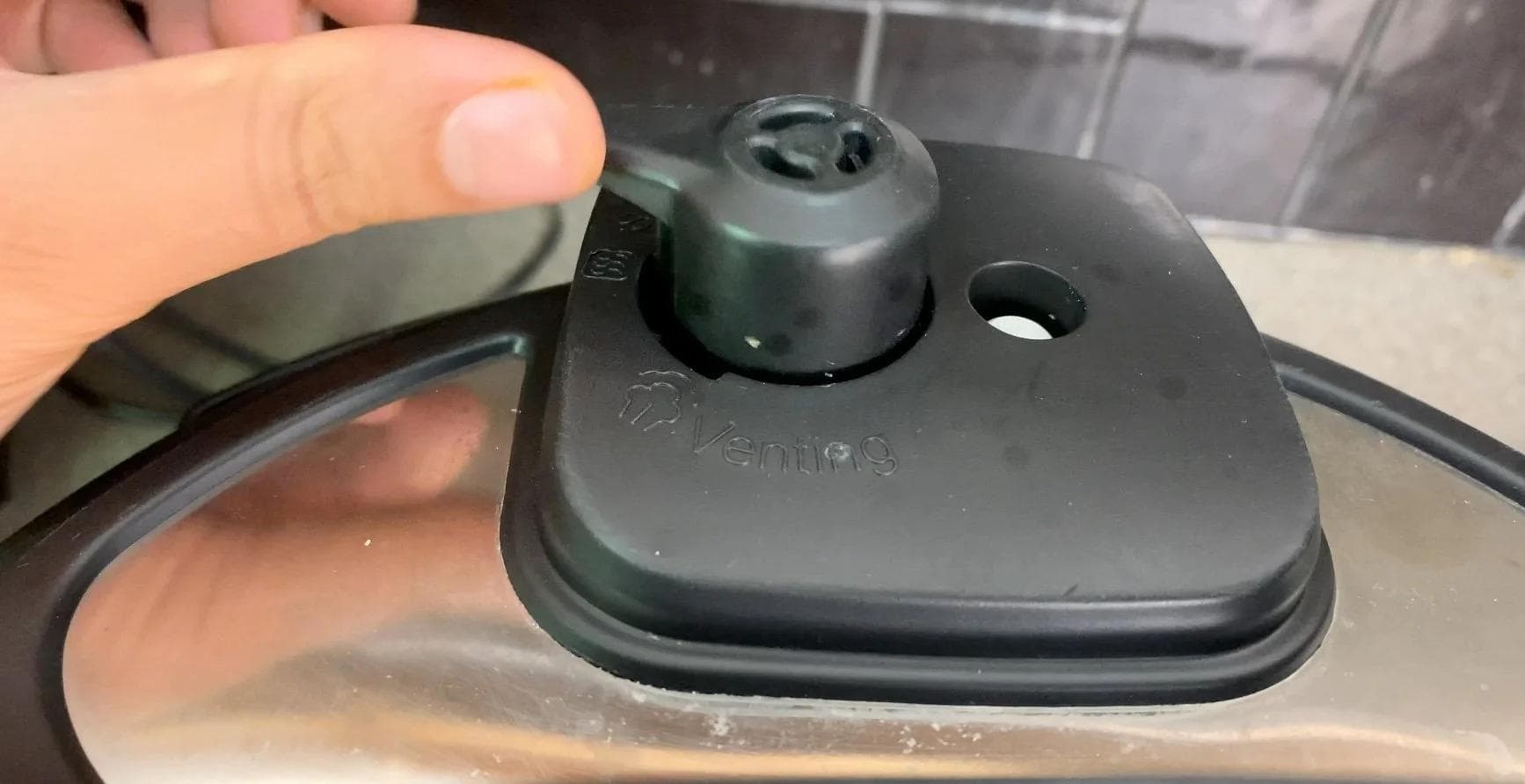 Instant Pot lid being placed in sealing mode before cooking beef chili for 18 minutes.
