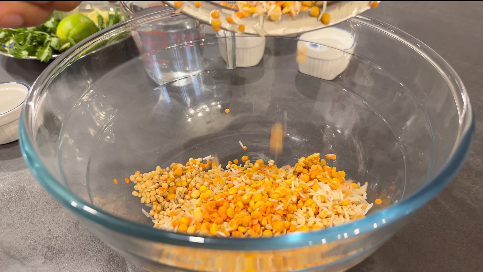 Washed lentils and rice soaking in water in a large glass bowl