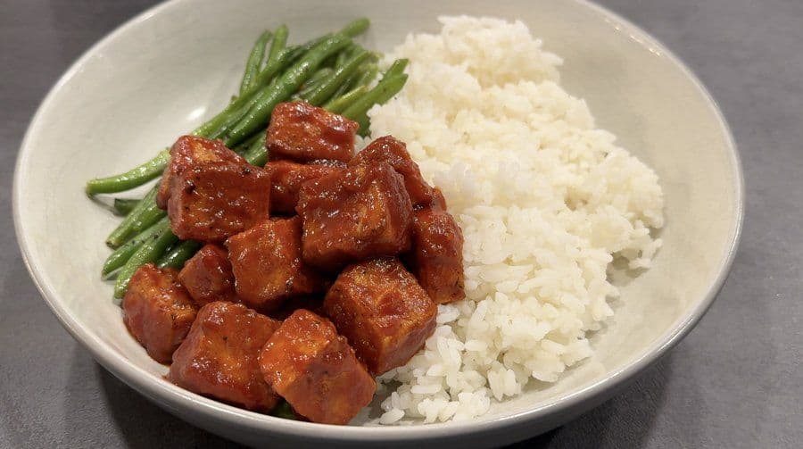 Crispy air fryer Korean tofu served in a bowl with steamed rice and green beans.